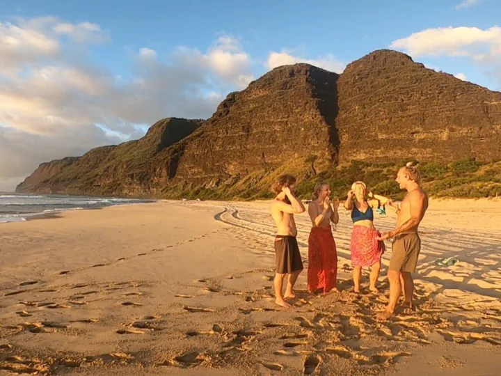 A group of friends smiling together after a SubMergence session on a Kaua'i beach
