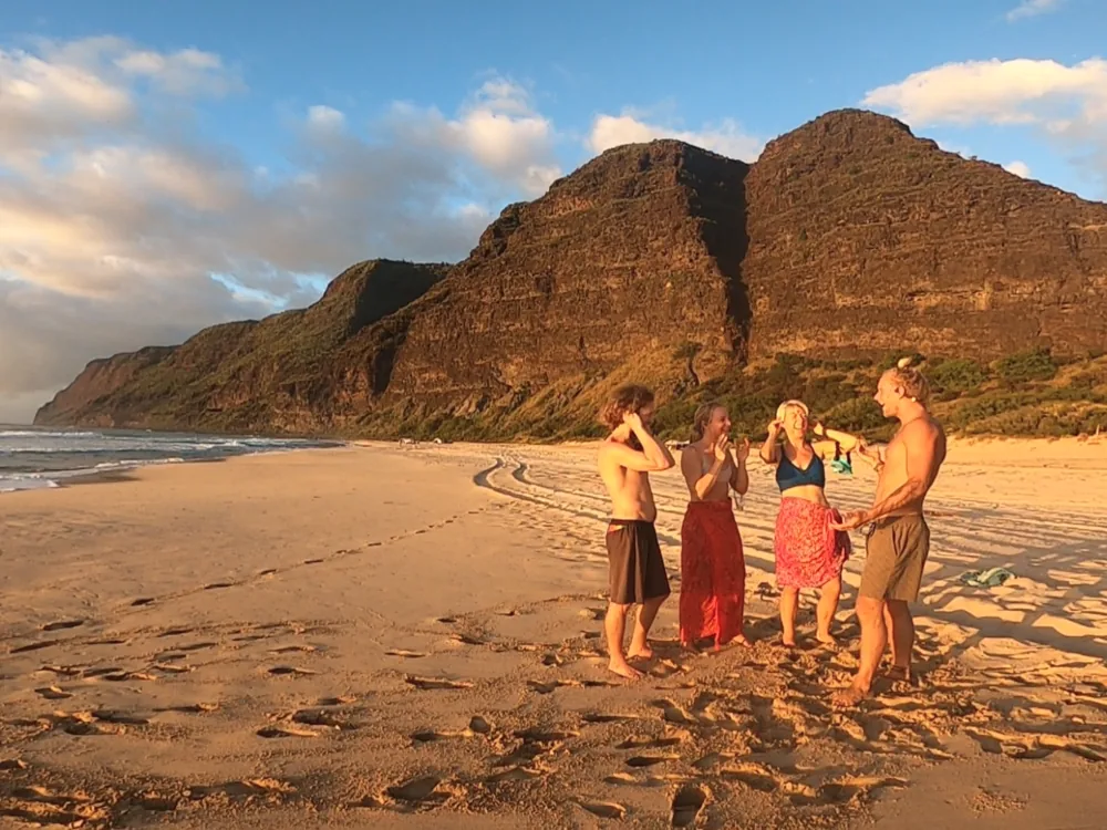 A group of friends smiling together after a SubMergence session on a Kaua'i beach